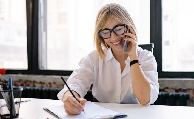 professional woman on phone while taking notes